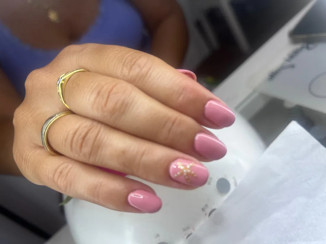 Manicura en rosa con una uña decorada con una estrella de perlas, trabajo de Estética Vintage Spa