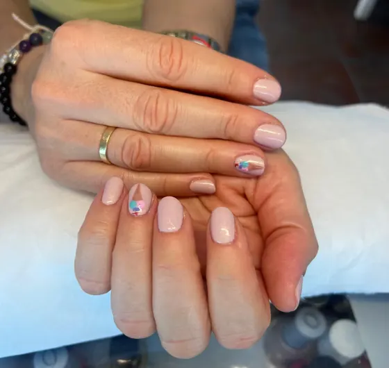Manicura en tono nude con pequeños detalles de colores, trabajo de Estética Vintage Spa